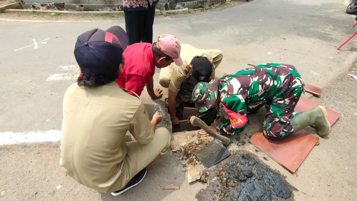 babinsa perbaiki jalan berlubang