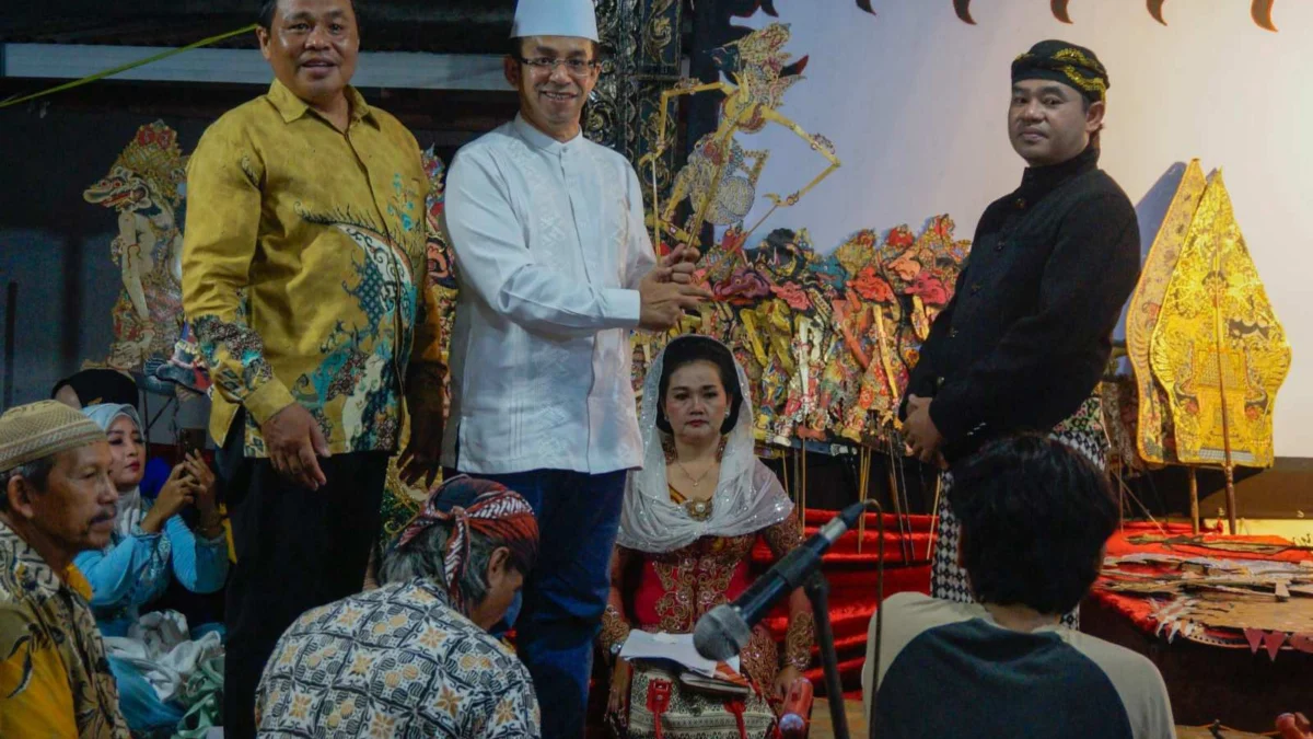 Rizal Bawazier menyerahkan wayang kulit karakter Kresno pada dalang Ki Khaerun Sudarno.