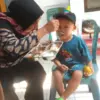 Seorang balita penerima manfaat program MBG tengah lahap menyantap makanannya.