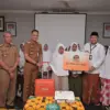 BTPN Syariah menyerahkan hadiah dari program Umrah Satu Pesawat pada nasabahnya di Desa Sentul.