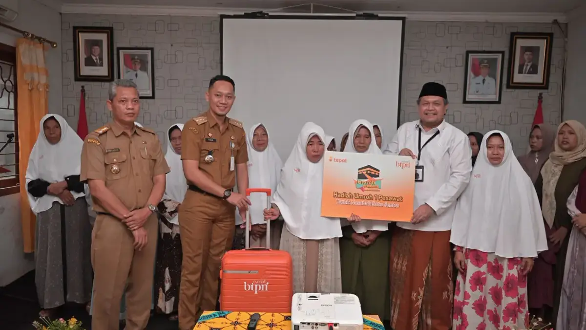 BTPN Syariah menyerahkan hadiah dari program Umrah Satu Pesawat pada nasabahnya di Desa Sentul.